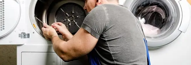 Dryer repair technician fixing a clothes dryer drum in Anchorage, AK