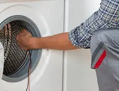 Dryer repair technician diagnosing and servicing a clothes dryer in Anchorage, AK