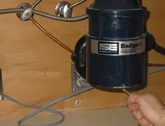 Garbage disposal repair technician tightening the mounting ring under a sink in Anchorage, AK