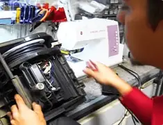 Vacuum repair technician servicing internal components on a workbench in Anchorage, AK