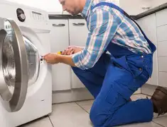 Washing machine repair technician servicing a front-load washer in Anchorage, AK