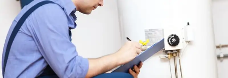 Water heater repair technician inspecting the unit and recording service notes in Anchorage, AK