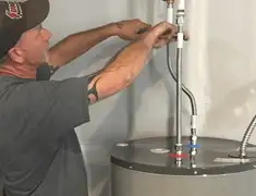 Water heater repair technician tightening supply line connections in Anchorage, AK